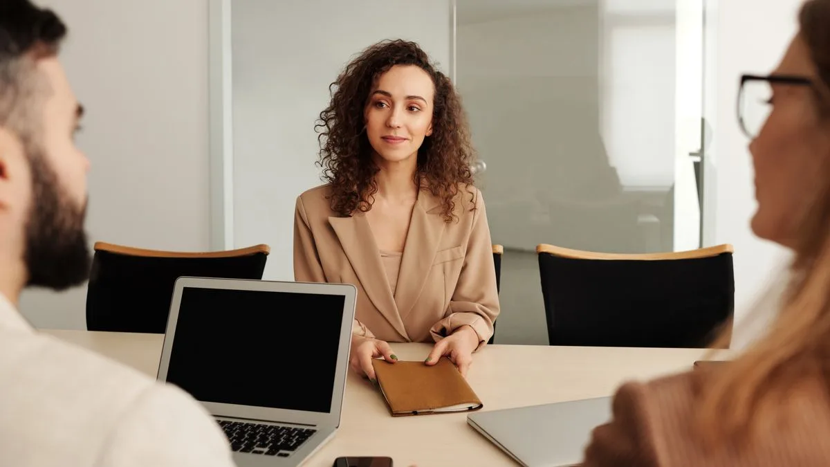 Bewerberin im Vorstellungsgespräch am Besprechungstisch, ihr gegenüber zwei Gesprächspartner